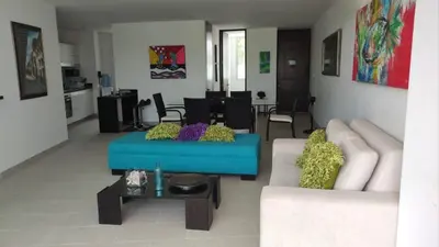 a living room with a blue couch and a table at Acogedor apartamento con vista al mar en coveñas in Coveñas