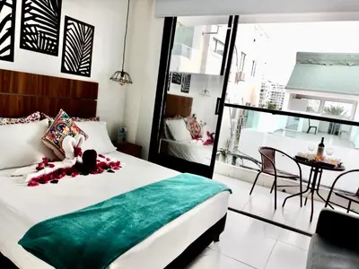 a bedroom with a bed with a green blanket and a table at Casa Colors in Cartagena de Indias
