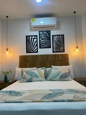 a bedroom with a bed with two lights above it at Casa Colors in Cartagena de Indias