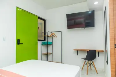 a bedroom with a green door and a desk at Casa Colors in Cartagena de Indias