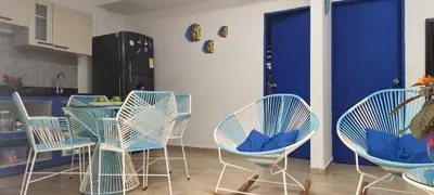 a kitchen with chairs and a table and a blue door at CABAÑA EN ISLA FRENTE A CARTAGENA in Cartagena de Indias