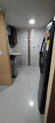 an empty room with a kitchen with a refrigerator at Hermosa casa amoblada in Barranquilla