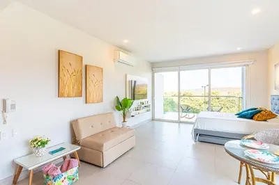 a bedroom with a bed and a living room at Lujoso Apto Cartagena - Acceso Directo a la Playa in Cartagena de Indias