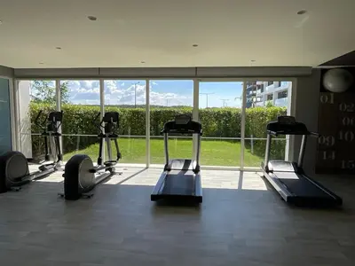 a gym with several tread machines in front of a large window at Lujoso Apto Cartagena - Acceso Directo a la Playa in Cartagena de Indias