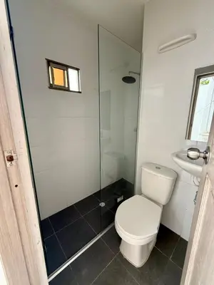 a bathroom with a toilet and a glass shower at Apartamento en el epicentro del Carnaval in Barranquilla