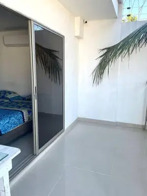 a room with a sliding glass door with a bed at Apartamento en el epicentro del Carnaval in Barranquilla