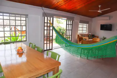 a room with a table and a hammock in it at Cabaña Macondo in Coveñitas
