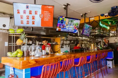 a bar with chairs and a man at a counter at King's Apartments 302 in Cartagena de Indias