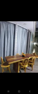 a wooden table and chairs in a room with curtains at Apartment by the sea in Puerto Colombia