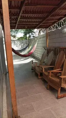 a porch with chairs and a hammock on a house at Apartment by the sea in Puerto Colombia