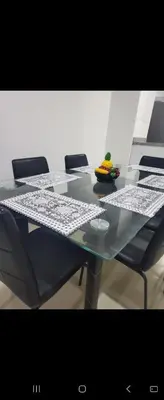 a glass table with chairs and a bowl of fruit on it at Apartment by the sea in Puerto Colombia