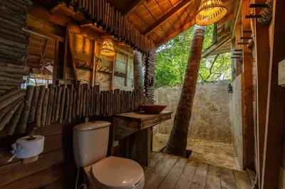 a bathroom with a toilet in a wooden house at CasaCoral Hotel in Isla Fuerte