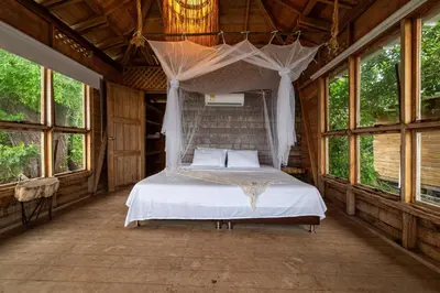 a bedroom with a bed in a room with windows at CasaCoral Hotel in Isla Fuerte