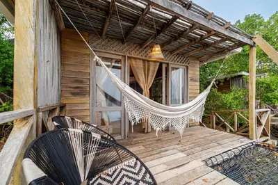 a hammock on the porch of a cabin at CasaCoral Hotel in Isla Fuerte