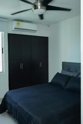 a bedroom with a blue bed and a ceiling fan at Apartamento moderno y centrado en Barranquilla in Barranquilla