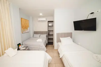 a hotel room with two beds and a flat screen tv at Abel Boutique House in Cartagena de Indias