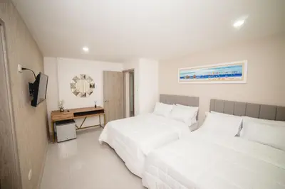 a hotel room with two beds and a television at Abel Boutique House in Cartagena de Indias