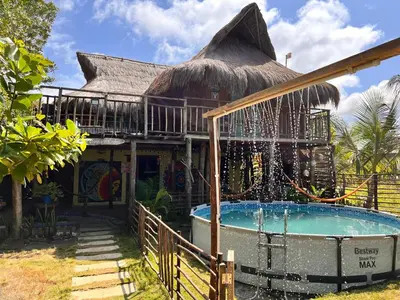 a house with a swimming pool in front of a building at Arcoiris EcoHotel in San Bernardo del Viento
