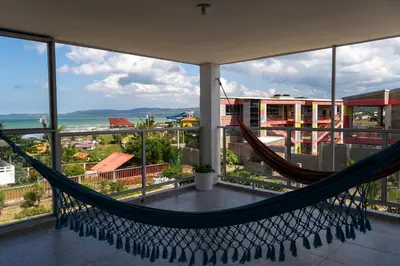 a hammock on a balcony with a view of the ocean at Villa Nuevo Amanecer Santa Verónica in Santa Veronica