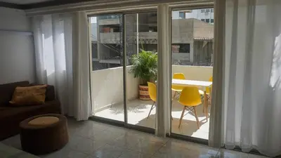 a living room with a couch and a table with yellow chairs at Azul de Bocagrande in Cartagena de Indias