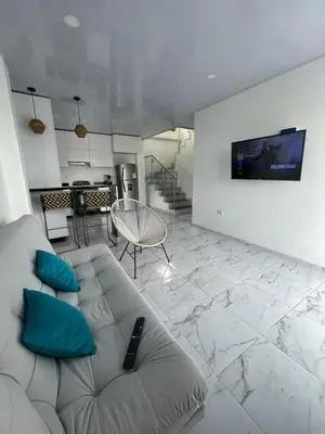 a living room with a couch and a tv on a wall at Casita Madrigal in Santa Veronica