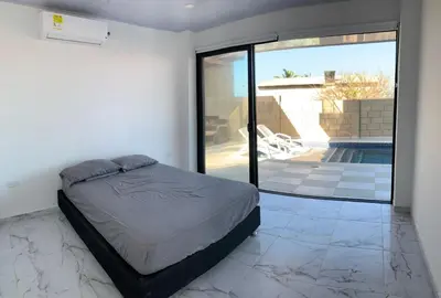 a bedroom with a bed and a swimming pool at Casita Madrigal in Santa Veronica