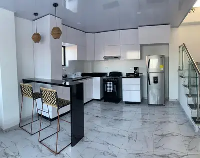 a kitchen with a black counter and a refrigerator at Casita Madrigal in Santa Veronica