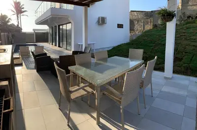 a dining table and chairs on a patio at Casita Madrigal in Santa Veronica
