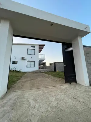 a white house with a black garage door at Casita Madrigal in Santa Veronica