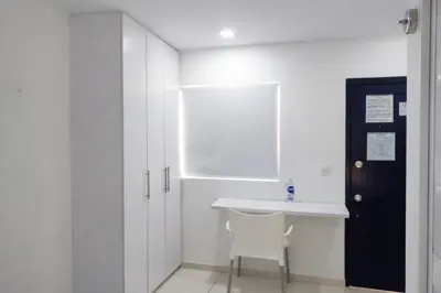 a white kitchen with a white sink and a white chair at Aparta estudios Mubarak in Barranquilla