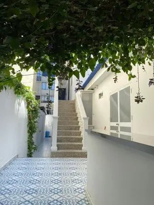 a stairway leading to a white building with a blue tile floor at Aparta estudios Mubarak in Barranquilla