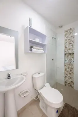 a white bathroom with a toilet and a sink at Aparta estudios Mubarak in Barranquilla