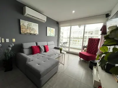 a living room with a couch and a red chair at Morros Cartagena junto al Hotel las Américas Edificio Spiaggia salida a playa in Cartagena de Indias