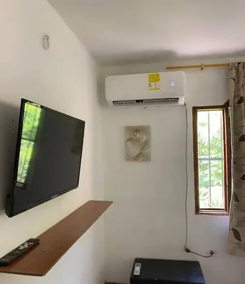 a room with a flat screen tv on a wall at Hotel Villa Mary apartaestudios playa in Maizal