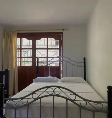 a bed in a bedroom with a window at Hotel Villa Mary apartaestudios playa in Maizal