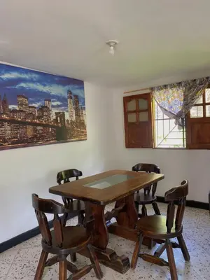 a dining room with a wooden table and chairs at Hotel Villa Mary apartaestudios playa in Maizal