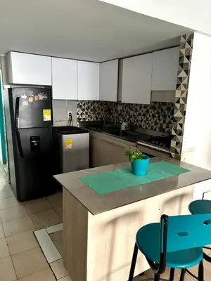 a kitchen with a refrigerator and a counter with chairs at Casa Grace Apto con vista al mar in Cartagena de Indias