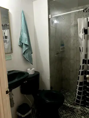 a bathroom with a black toilet and a shower at Casa Grace Apto con vista al mar in Cartagena de Indias