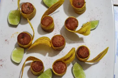 a white plate with a banana peel and meatballs at VAIA HOTELES in Coveñas