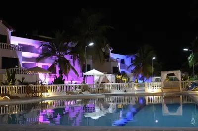a swimming pool in front of a building at night at VAIA HOTELES in Coveñas