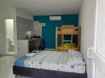 a small bedroom with a bed and a blue wall at PLAYA MAG in Coveñas