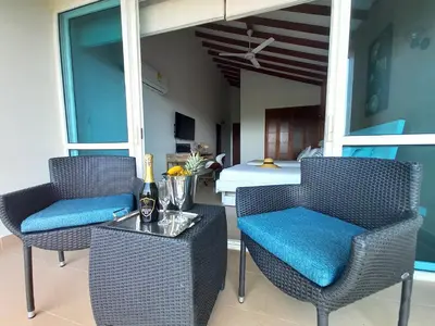 a patio with two chairs and a table with a bed at Beach Villa Sol & Mar Cartagena, beachfront & private pool in Cartagena de Indias