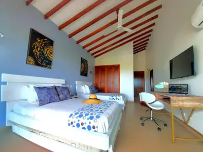 a bedroom with a bed and a desk and a television at Beach Villa Sol & Mar Cartagena, beachfront & private pool in Cartagena de Indias
