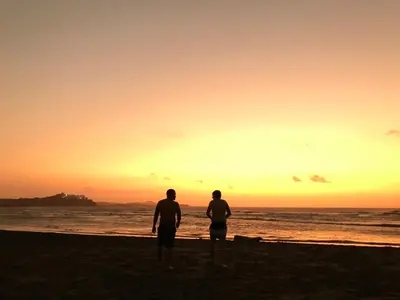 two men standing on the beach watching the sunset at California House in Santa Veronica