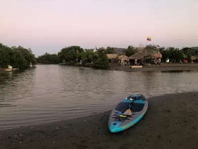 a blue kayak sitting on the shore of a river at California House in Santa Veronica
