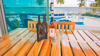 a wooden table with wine bottles and glasses on it at Magico Apartamento Frente al Mar 3 Habitaciones PAZ224 in Coveñitas