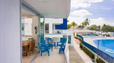 a balcony with a table and chairs and a swimming pool at Magico Apartamento Frente al Mar 3 Habitaciones PAZ224 in Coveñitas