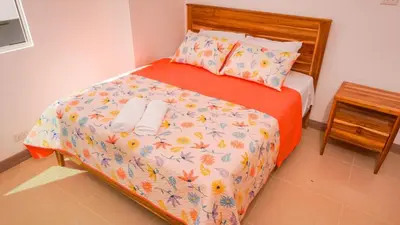 a bedroom with a bed with orange sheets and flowers at Magico Apartamento Frente al Mar 3 Habitaciones PAZ224 in Coveñitas