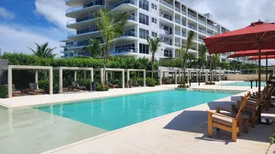 a swimming pool with chairs and a large building at Apartamento de Lujo Morros Zóe - Manzanillo - Cartagena in Cartagena de Indias