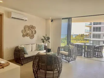 a living room with a couch and chairs and a balcony at Apartamento de Lujo Morros Zóe - Manzanillo - Cartagena in Cartagena de Indias
